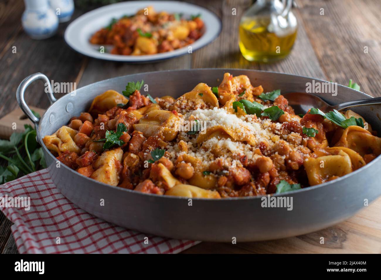 Kichererbsengericht mit Tortellini, Pancetta, Gemüse in einer köstlichen Tomatensauce. Serviert mit Parmesankäse. Stockfoto