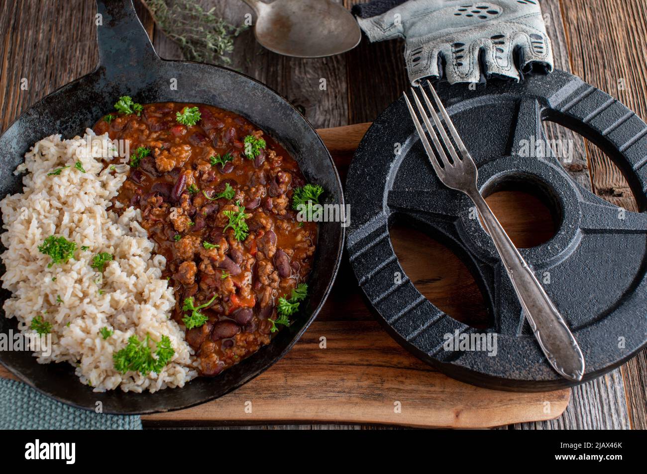 Fitnessmenü mit braunem Reis und würzigem Bohneneintopf mit gemahlenem Rindfleisch und Gemüse Stockfoto