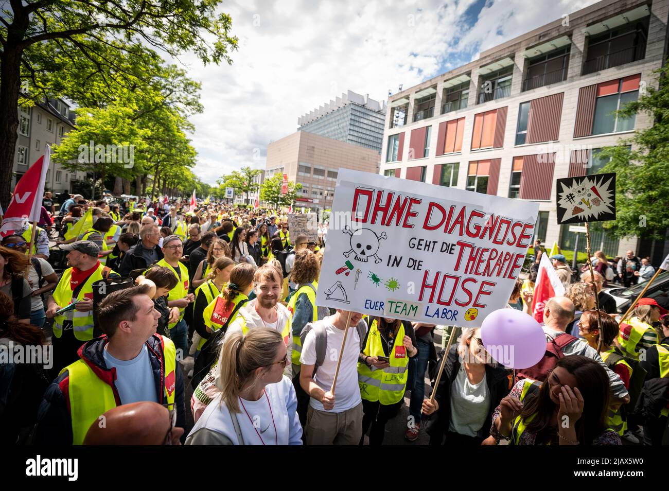 Köln, Deutschland. 01.. Juni 2022. „Ohne Diagnose geht die Therapie den Bach runter“ steht auf dem Banner, das von Mitarbeitern eines Labors bei einer Demonstration getragen wurde. Die Streiks von Beschäftigten in sechs Universitätskliniken in Nordrhein-Westfalen im Kampf für einen Tarifvertrag über die Hilfe haben bereits einen Monat gedauert. Es gab viele Verhandlungstermine, aber bisher gab es kein Angebot der Krankenhausleitungen. Quelle: Christian Knieps/dpa/Alamy Live News Stockfoto