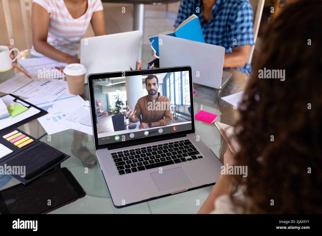 Geschäftsmänner unterweisen weiblichen Kollegen Arbeitsstrategien durch Videokonferenz im Büro Stockfoto