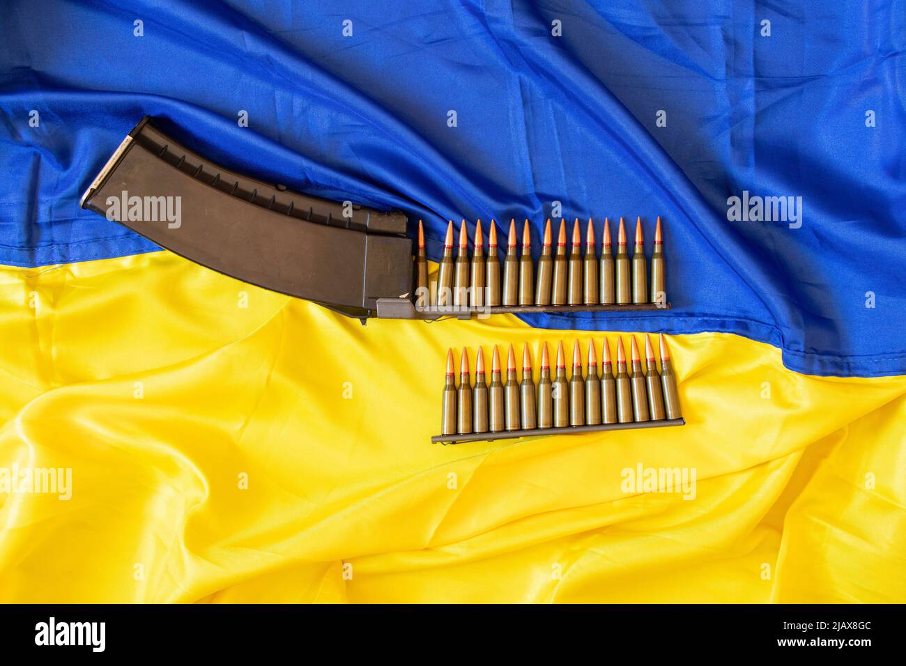 Kugeln im Horn liegen auf der gelb-blauen Flagge der Ukraine, Krieg in der Ukraine, Verteidigung des Mutterlandes, Waffen, Kugel 2022 Stockfoto
