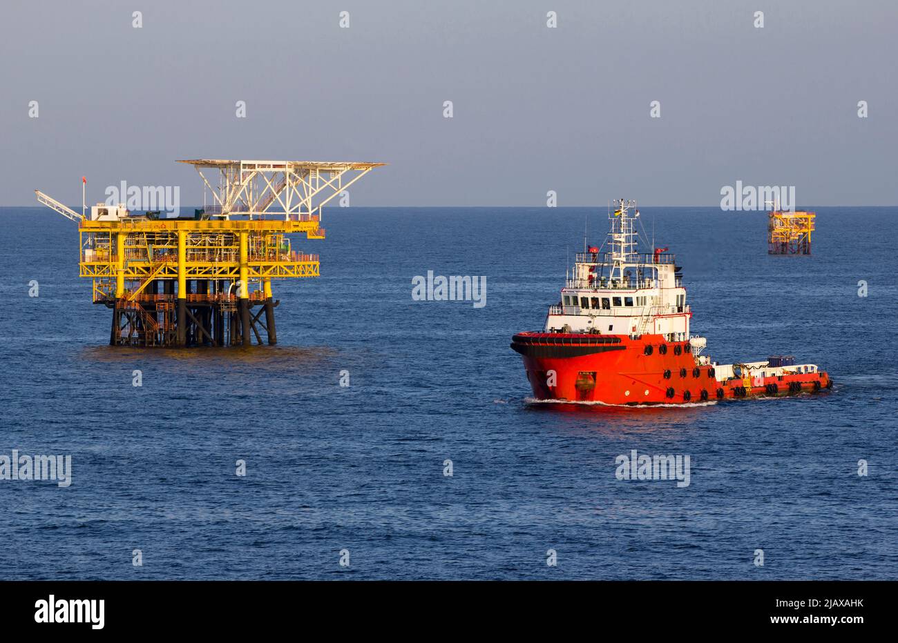 Ölbohrinseln mit Versorgungsboot für den Transport von Menschen oder Materialien zu nahe gelegenen Bohrinseln, Südchinesisches Meer, Malaysia Stockfoto