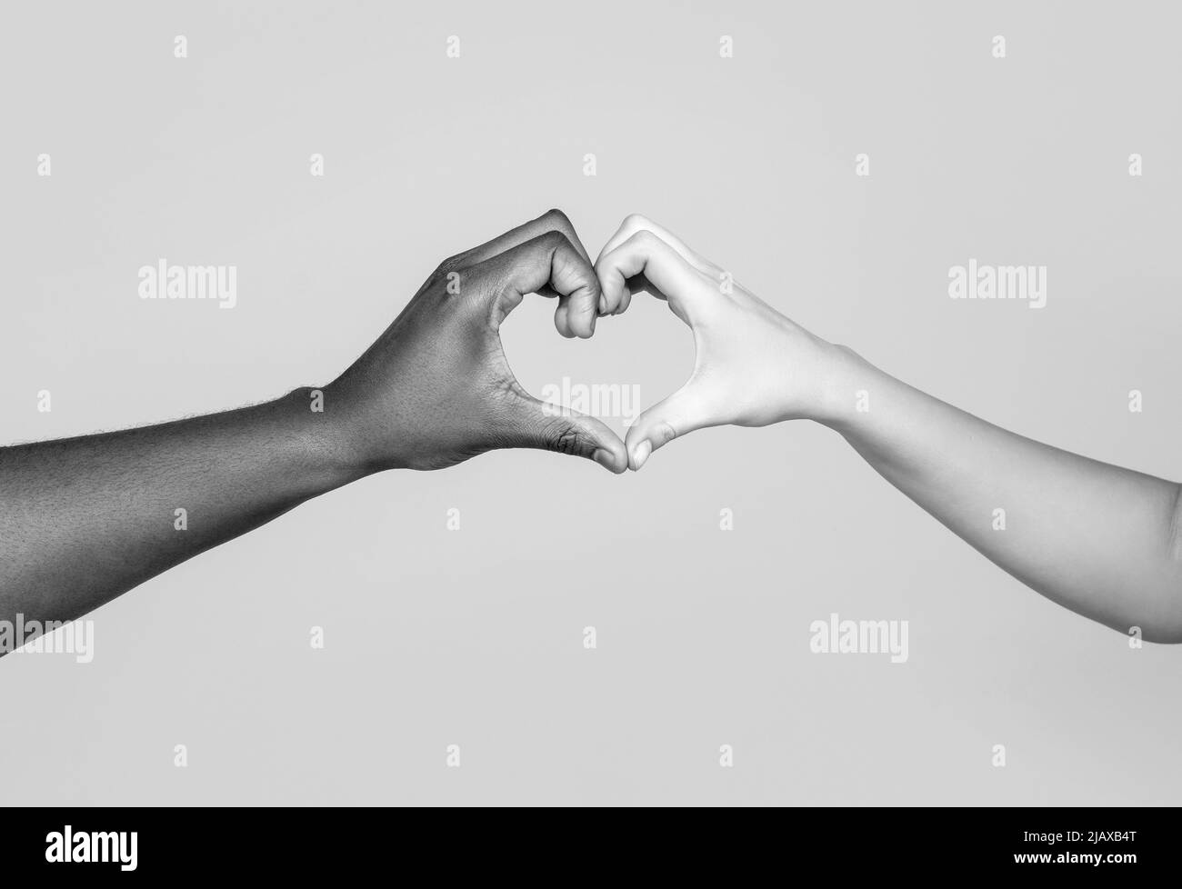 Menschen verschiedenen Hautfarben setzen ihre Hände zusammen, so dass Herz in weißen Hintergrund. Nächstenliebe, Liebe und Vielfalt - Nahaufnahme von Frau und Mann Stockfoto