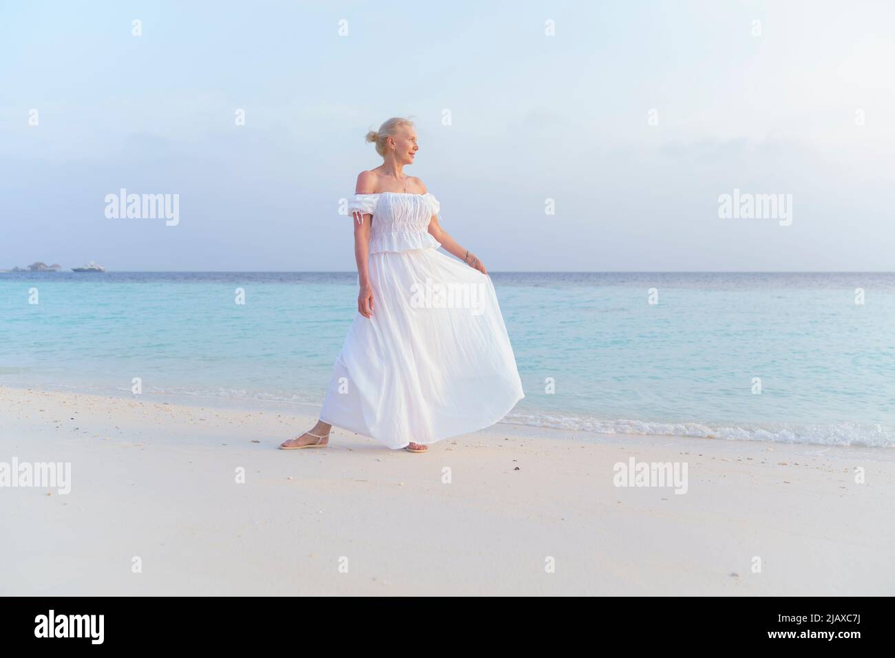 Eine Frau in einem weißen Kleid auf dem Meer. Stockfoto