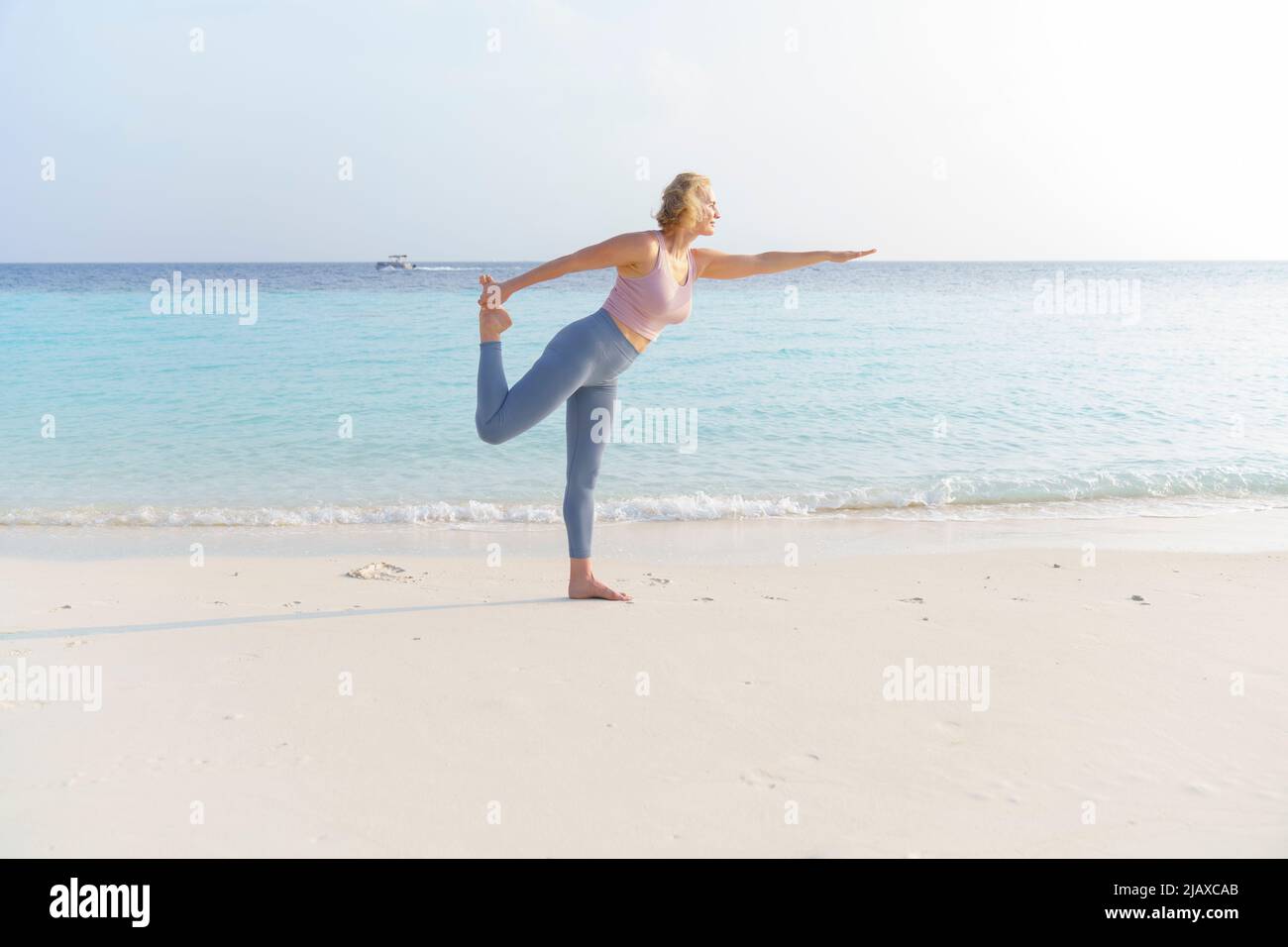 Eine sportliche Frau macht am Strand Sport. Stockfoto