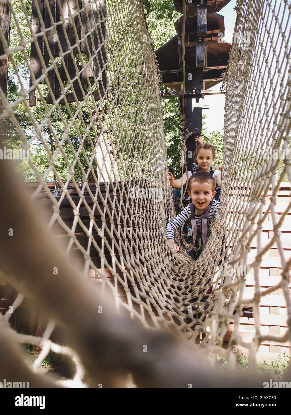 Fröhliche Kinder im Netz im Seilpark Stockfoto