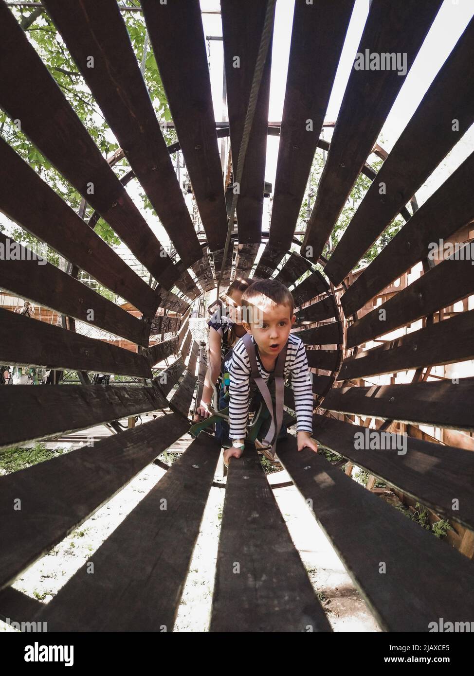 Netter Junge in einem Seilpark. Lebensstil Kind körperliche Aktivität Stockfoto
