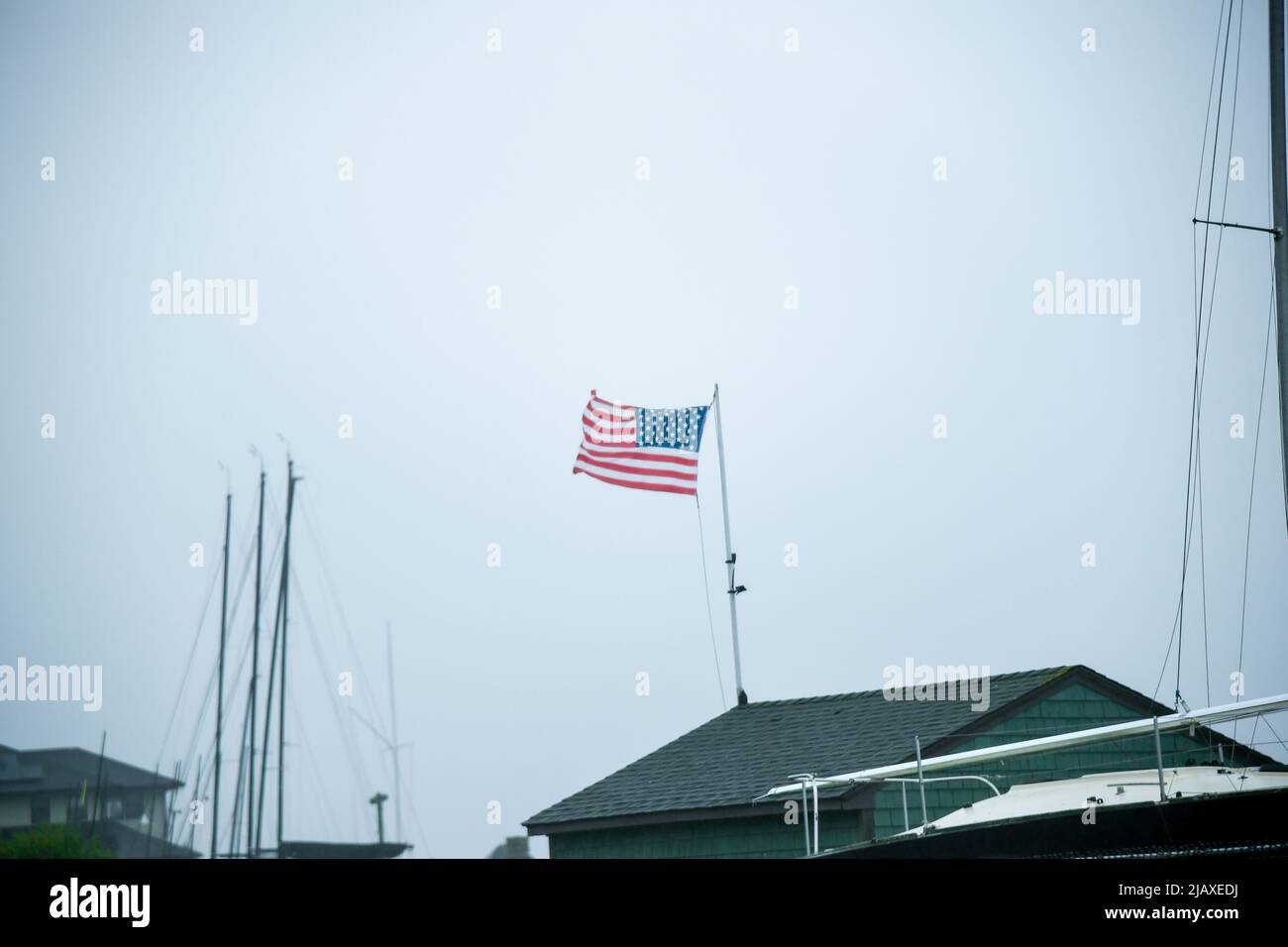Stock-Fotos von Tropical Storm Elsa aus dem Jahr 2021 Drenching Newport, Rhode Island. Blick auf Regen und amerikanische Flagge auf der Windschutzscheibe während eines Sturms. Stockfoto