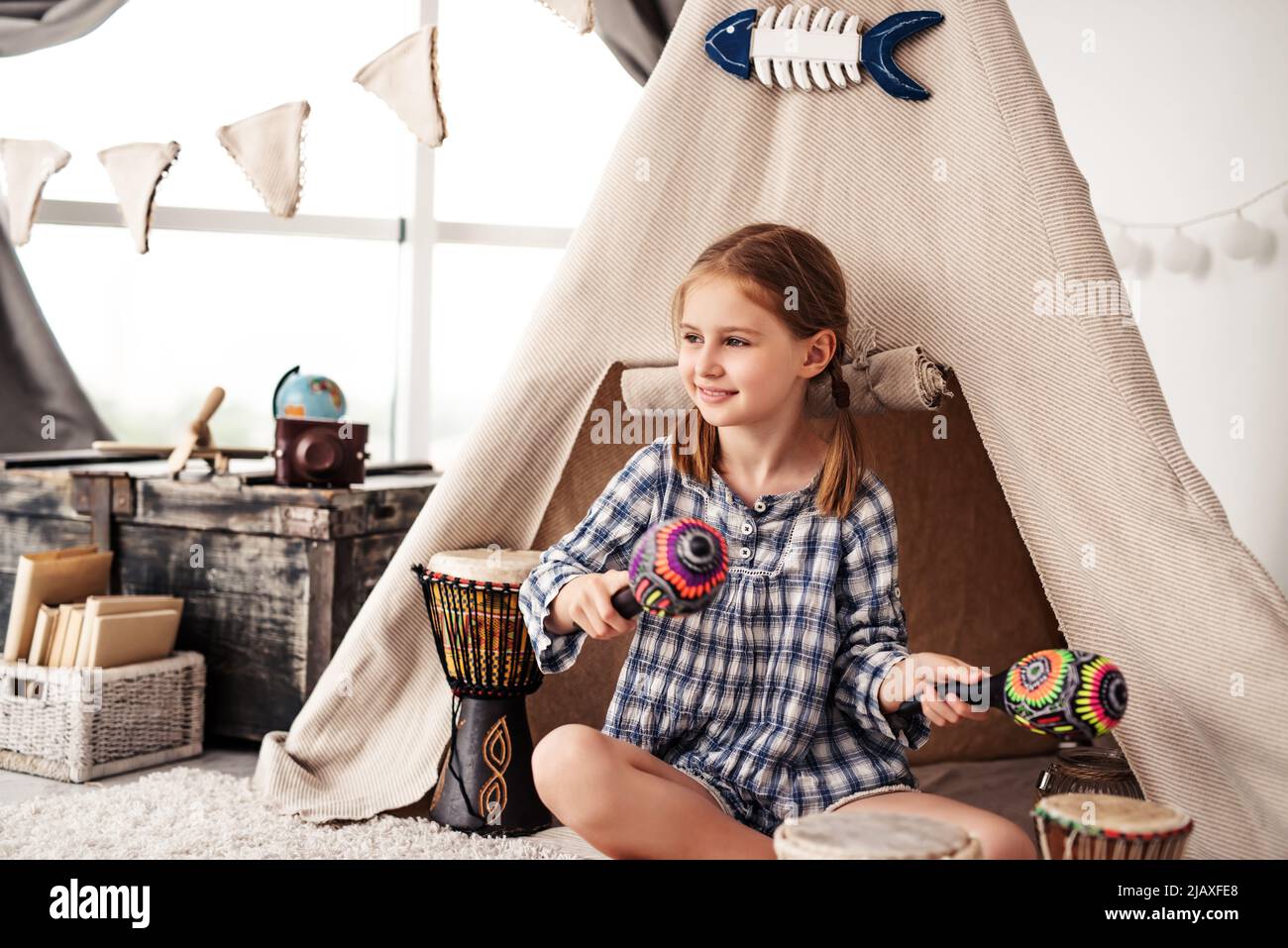 Kleines Mädchen mit Maracas und Djembe-Trommeln Stockfoto