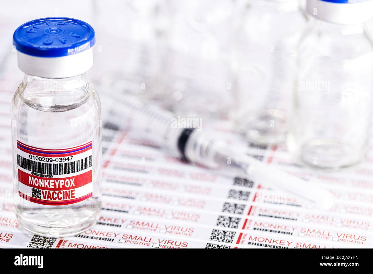 Ampulle oder Fläschchen mit Monkeypox-Virus-Impfstoff mit Gefahrenetiketten und Warnhinweisen im Hintergrund Stockfoto
