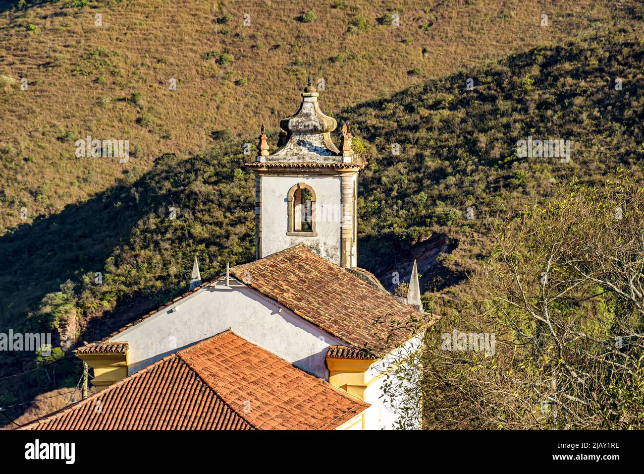Die Kirche und ihr Glockenturm von hinten mit dem Hügel und seiner Vegetation im Hintergrund in der Stadt Ouro Preto Stockfoto