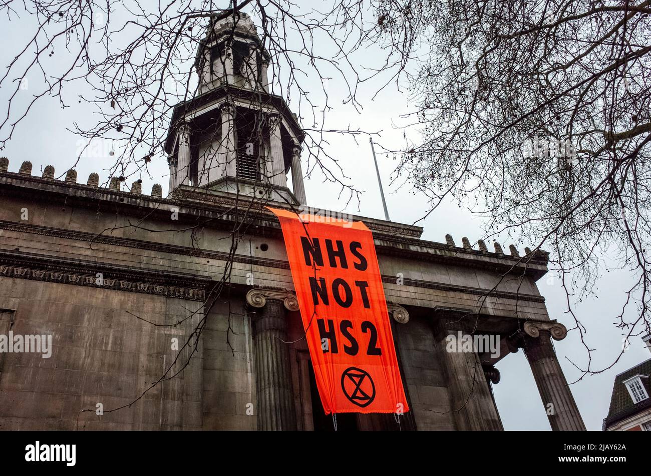 Das Banner der Kampagne „NHS Not HS2“ hängt an der St Pancras New Church entlang der Euston Road, außerhalb des Euston Bahnhofs in London - 2021 Stockfoto