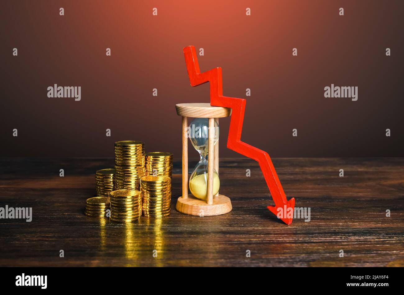 Geld, Sandglas und Pfeil nach unten. Senkung der Stundenlöhne. Sparen Sie Ersparnisse vor Inflation. Sinkende Einkommen. Sinkende Hypothekenzinsen. Sinkende Rendite Stockfoto