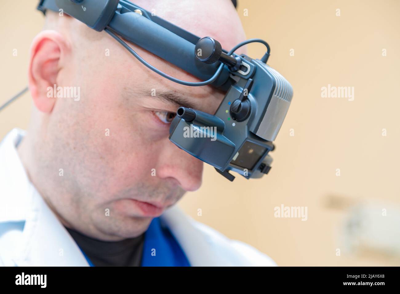 Ein männlicher Augenarzt überprüft das Sehvermögen eines Patienten mit einem binokularen Ophthalmoskop. Stockfoto