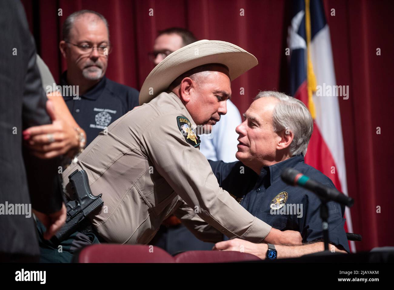 Uvalde Texas USA, 25 2022. Mai: Texanische Staatsbeamte, darunter der Sheriff RUBEN NOLASCO von Uvalde County, umarmte den Gouverneur. GREG ABBOTT hielt eine Pressekonferenz an der Uvalde High School, einen Tag nachdem ein 18-jähriger Schütze die Robb-Grundschule betreten hatte und 19 Schüler und zwei Lehrer getötet hatte. ©Bob Daemmrich Stockfoto