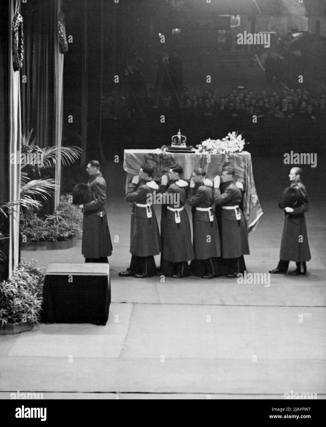 Der Sarg von König Georg VI. Wird von einer Trägerpartei der King's Company getragen und vom Zug am Kings Cross übernommen, wo er auf den Waffenwagen der King's Truppe gestellt wurde. 11. Februar 1952. (Foto von Daily Mirror). Stockfoto
