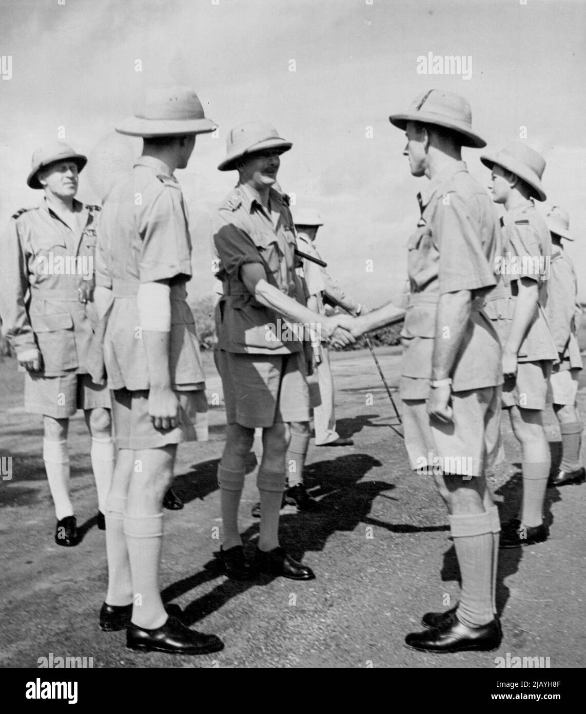 Herzog von Gloucester, während des Besuchs von R.A.F. Jagdflugplatz in der Nähe von Kalkutta, schüttelte die Hände und unterhielt sich mit Sergeant Pilot J.R. McRae aus St. Kilda, Melbourne, der in Burma ein Jap-Flugzeug abschoss und andere beschädigte. Offiziere und Männer, die an der Inspektion teilnahmen, wurden angewiesen, Buschröcke zu tragen -- einen offenen Khakhi-Mantel, der wie Norfolk gejagt wurde -- den Herzog für seine Reisen in Indien bevorzugte. Dies war das erste Mal, dass Buschhemden als Teil der R.A.F. Uniform anerkannt und zugelassen wurden. 22. Juni 1942. Stockfoto