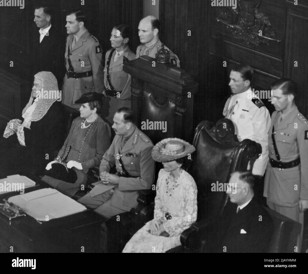 Der Herzog von Gloucester hörte sich gestern die Lesung seiner kommission während der Vereidigung im Parlamentsgebäude in Canberra an. In der Gruppe, von links nach rechts, befinden sich (sitzend) der Oberjustiz, Sir John Latham; Mrs. Curtin; der Herzog und die Herzogin; der Premierminister, Mr. Curtin. Hintere Reihe: Herr Ian Emerton (Usher der schwarzen Rute) und Kapitän Wynter, Major Hawkins, Brigadier Schreiber, Leutnant Commander Robertson, Kapitän Ramsay, Mitarbeiter des Herzogs. 31. Januar 1945. Stockfoto