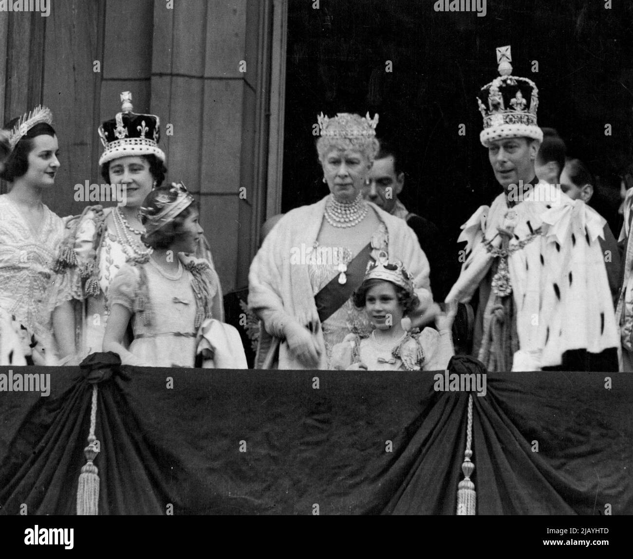 König George VI., der nach der Krönung die Krone des Kaiserlichen Staates trug, auf dem Balkon des Buckingham Palace, wo er den Jubel der riesigen Menschenmassen annahm, die sich versammelt hatten, um den neu gekrönten Souverän zu loben. Mit ihm sind Königin Elizabeth, Königin Mary, Prinzessin Elizabeth und Prinzessin Margaret. Die Prinzessinnen tragen ihre Krönungen, die sie nach der Krönung der Königin mit den Peeresses anziehen. 3. Juni 1953. Stockfoto