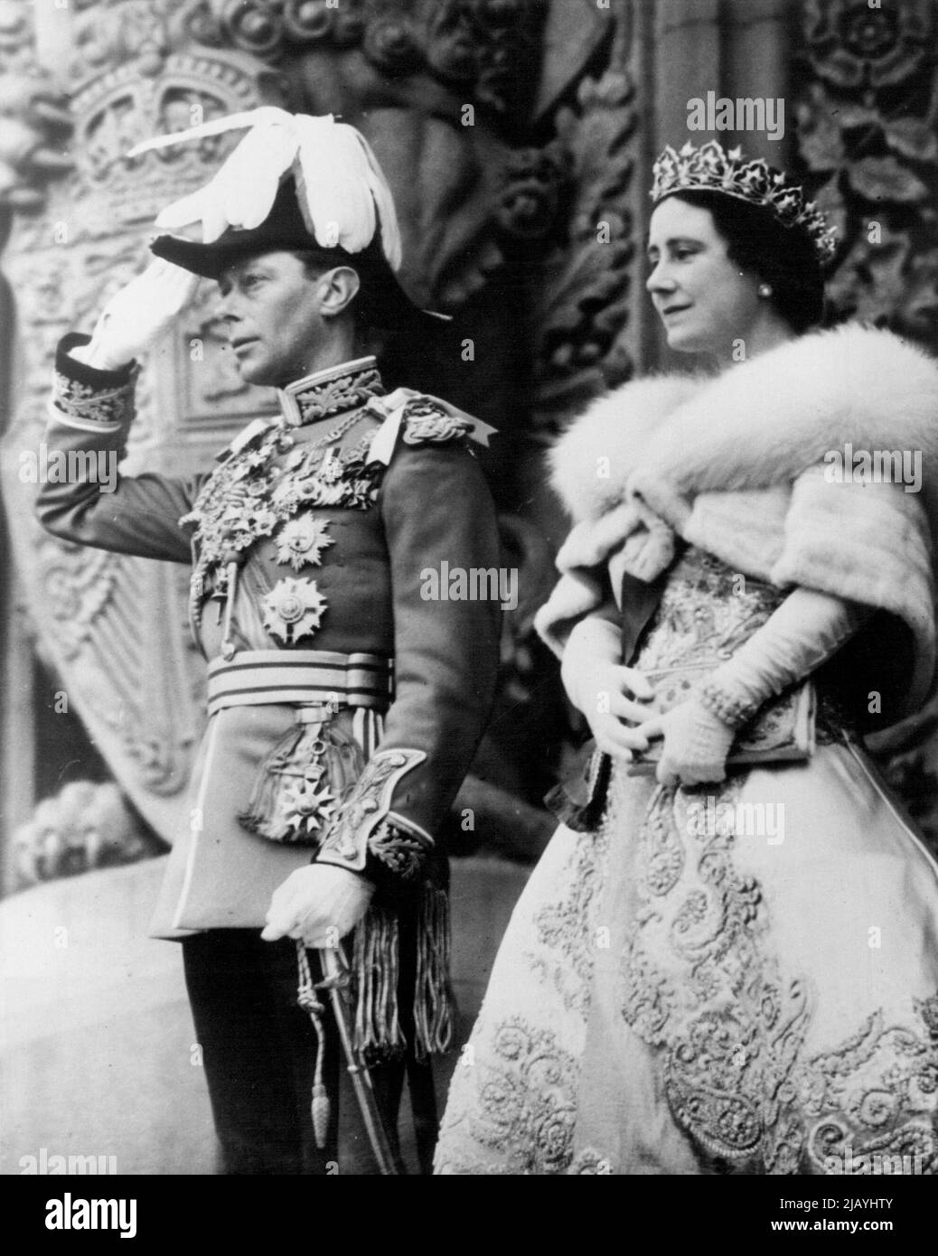 Royal Salute in Ottawa -- König George VI. Hebt seine Hand in Royal, Salute on the Steps of Parliament Building, Ottawa, Mai 19.. Neben dem König, der in der Uniform eines Feldmarschalls der britischen Armee gekleidet ist, steht Königin Elizabeth, die eine diamantene Tiara und einen kurzen Umhang aus blauen Fuchsfellen trägt. 20.Mai 1939. (Foto von ACME). Stockfoto