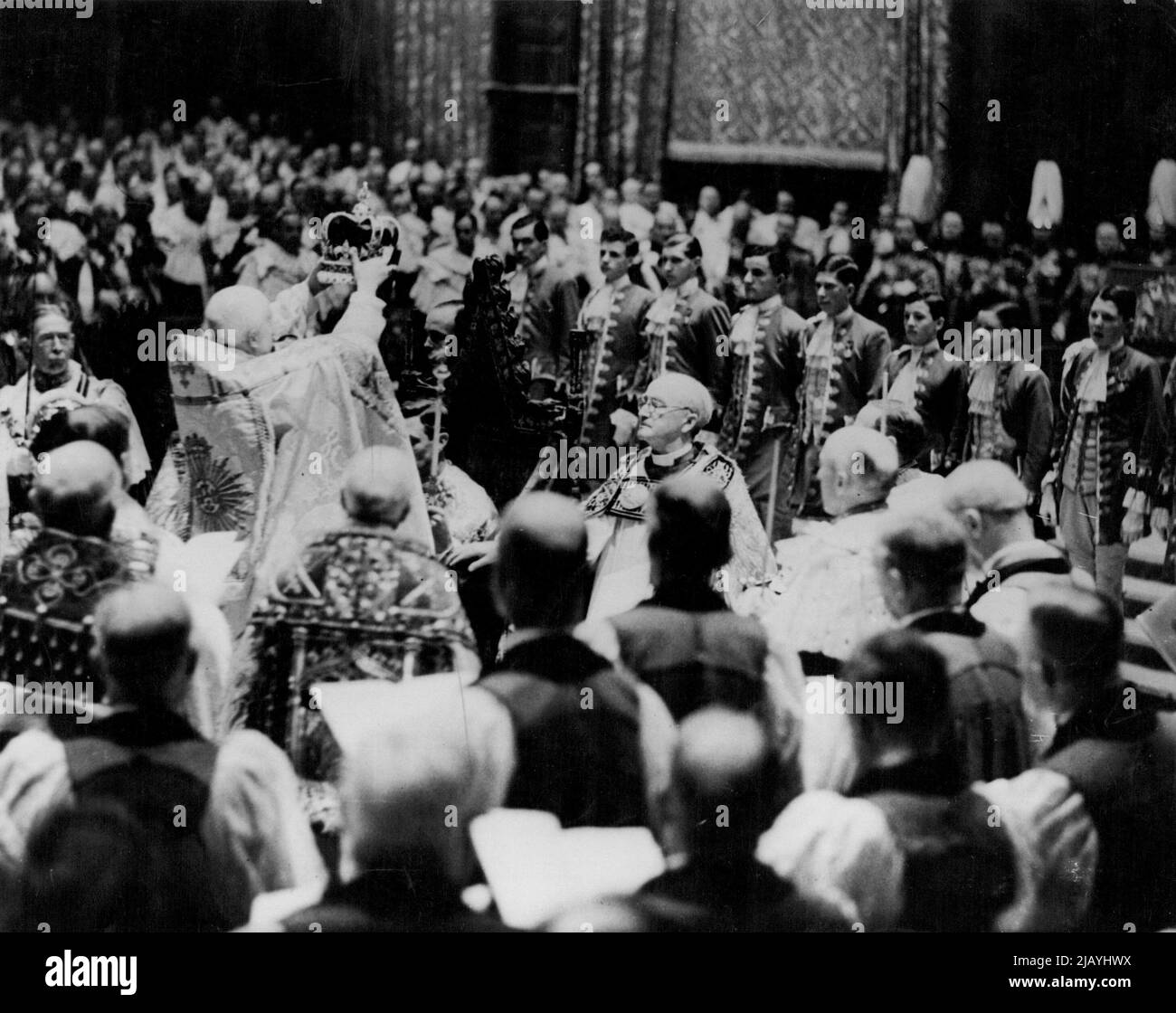 Der Moment der Majestät als König George VI. Am 12. Mai 1937 in Westminster Abbey zum König und Kaiser gekrönt wurde. Der Erzbischof von Canterbury, der die Krone von St. Edward vom Dekan von Westminster nahm, stellte sie ehrfürchtig auf den Kopf des Königs. Dabei wurde die tiefe Stille in der Abtei durch die lauten und wiederholten Schreie von „Gott rette den König“ gebrochen. 17. März 1953. (Foto von Daily Mirror). Stockfoto