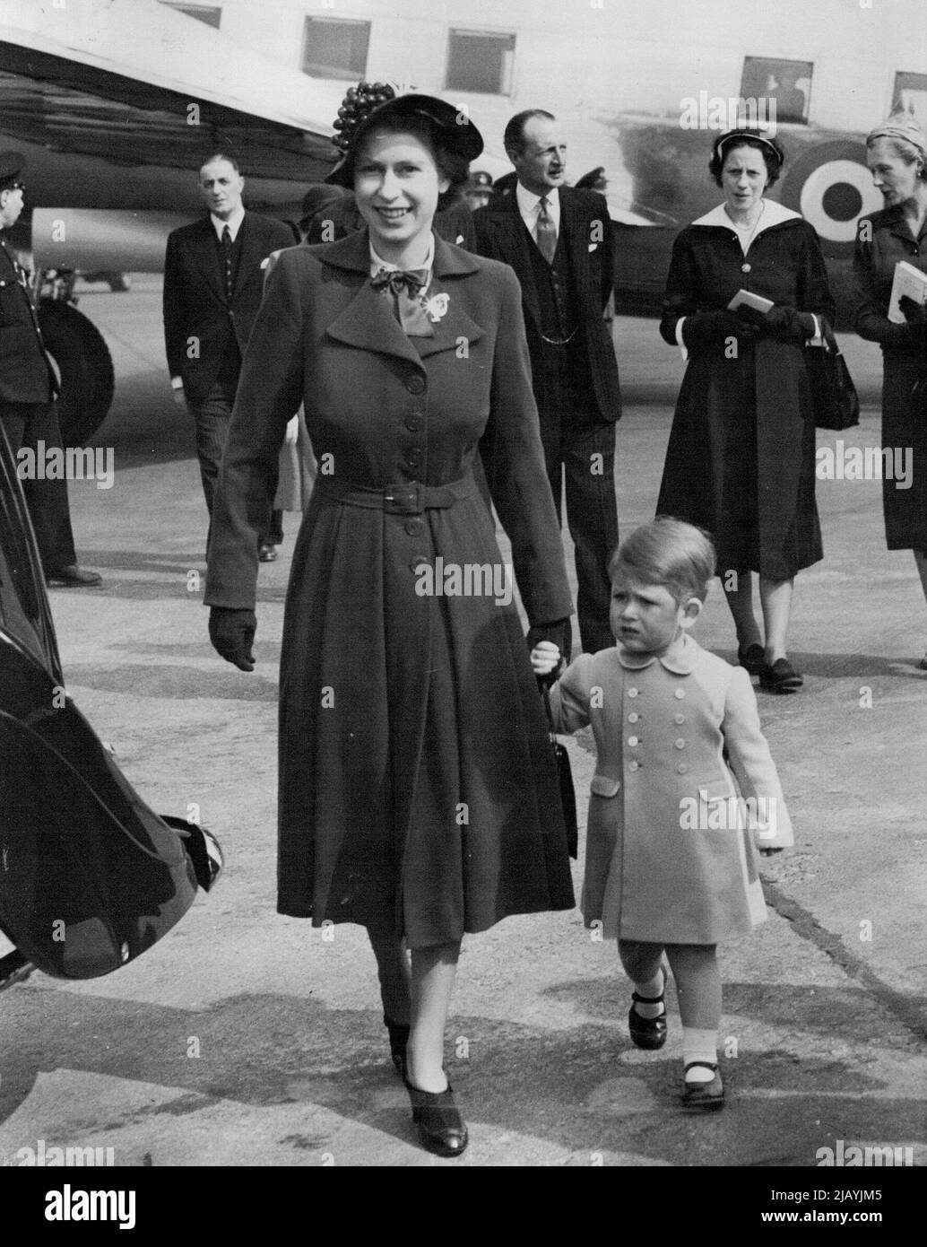 Prinz Charles Willkommen zu Hause für Mutter : Prinz Charles hält die Hand seiner Mutter Prinzessin Elizabeth, als sie zu Fuß zum Royal Auto am Flughafen London heute (Dienstag), als die Prinzessin nach ihrem Besuch nach Hause mit dem Herzog von Edinburgh nach Hause zurückgekehrt. Der Prinz war dort, als das Wikingerflugzeug des King's Flight landete, und er stieg in das Flugzeug, um seine Mutter zu begrüßen. 24. April 1951. (Foto von Reuterphoto). Stockfoto