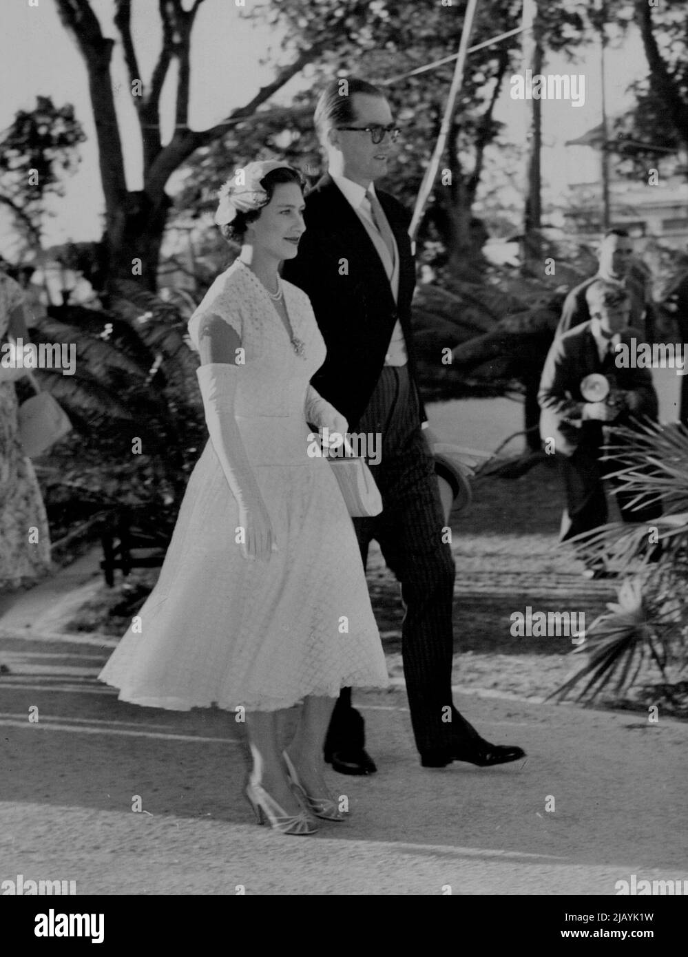 In Begleitung von Sir Kenneth Blackbourne, dem Gouverneur von Antigua, geht Prinzessin Margaret während ihrer Tour durch die Westindischen Inseln zu einer Gartenparty vom Government House in St. John's. 22. Februar 1955. Stockfoto