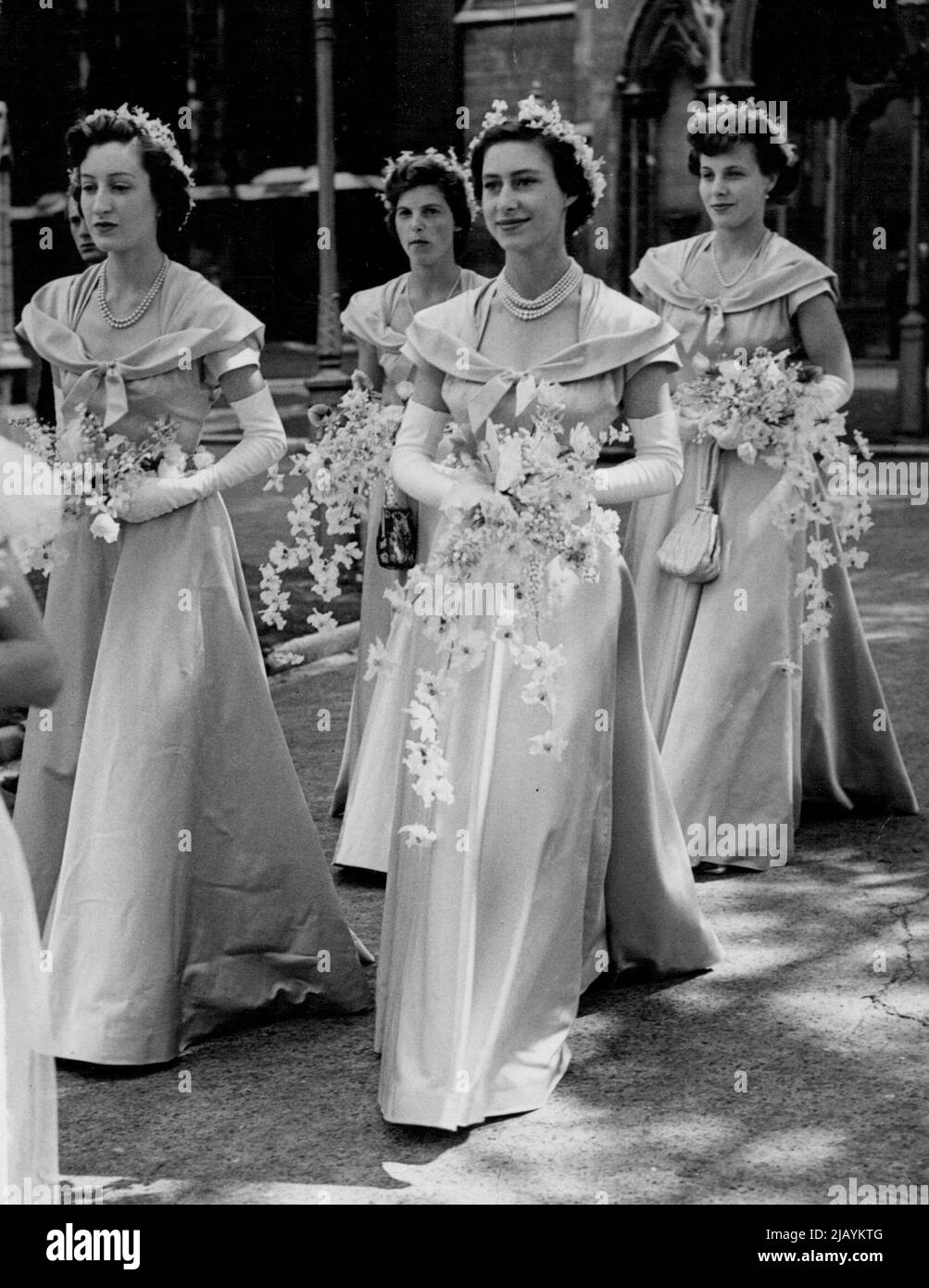 Prinzessin Margaret, Eine Brautjungfer bei der Hochzeit der Nichte der Königin - die Brautjungfern, in Orchideenrosa mit weißen Blumensträußen. Rechts ist Prinzessin Margaret und links Miss Diana Bowes-Lyon. Hinten links sehen Sie Miss Jeannine Bridgeman und Miss Marigold Bridgeman. Prinzessin Margaret war eine von vier Brautjungfern bei der heutigen Hochzeit der Nichte der Königin, der Hon Margaret Elphinestone, Tochter von Lord und Lady Elphinestone, in St. Margaret's Westminster, London. Der Bräutigam war Herr Denys Rhodes, der ältere Sohn des verstorbenen Majors Tahu Rhodes und Frau Helen Rhodes. 31. Juli 1950. (Foto von Paul Popper Ltd.). Stockfoto