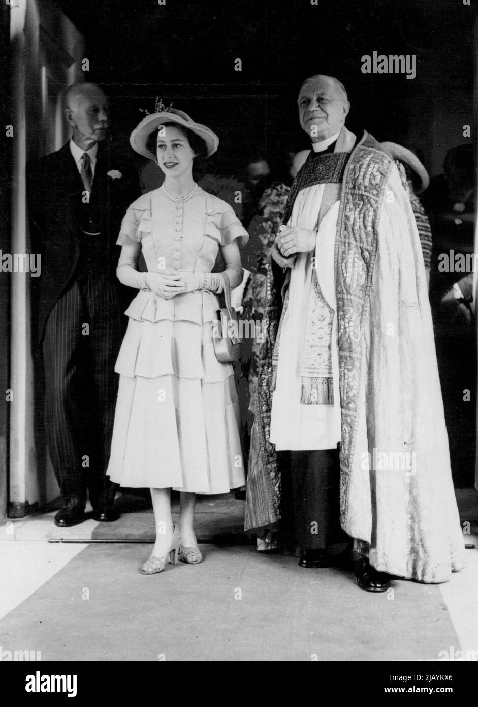 Prinzessin Margaret mit dem PrebendaryKirk, Vikar von St. Peter's nach der Zeremonie heute. Die Hochzeit fand heute zwischen Miss Rachel Brand und dem Hon William Douglas Home im St. Peter's Eaton Square statt. Prinzessin Margaret eine enge Freundin der Braut besuchte die Hochzeit. Prinzessin Margaret. . . „Letzte Woche trug sie drei Tage in Folge dasselbe kleine gelbe Kleid.“ 26. Juli 1951. Stockfoto