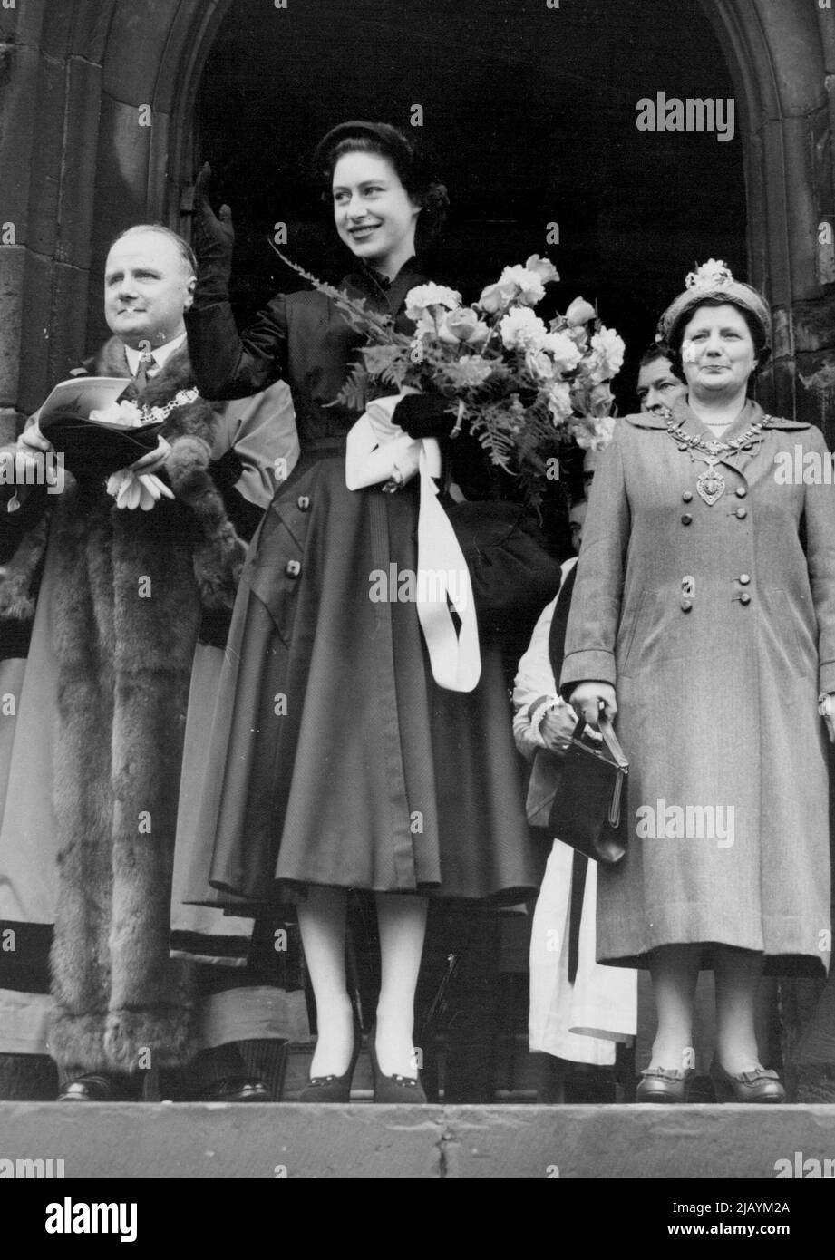 Lächelnde Prinzessin -- in einem schwarzen, mit Kordeln bestückten Seidenmantel mit schwarzen Accessoires hält Prinzessin Margaret ihren Strauß aus rosa Rosen, Nelken und Farn, während sie den Jubel der Menge anerkennt, nachdem sie an einem Gottesdienst zum Gedenken an Rotherhams goldenes Jubiläum als Countv Borough teilgenommen hat. Früher, die Nordtür der 15.. Century Parish Church of Rotherham, versiegelt für mehr als ein Jahrhundert, wurde geöffnet, damit die Prinzessin nach dem Gottesdienst durchgehen konnte. 19. April 1953. (Foto von United Press Photo). Stockfoto