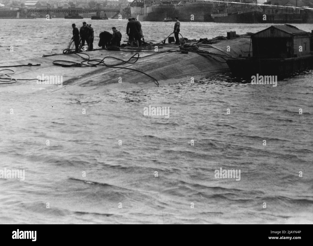 Der Frachter, der nach einem verheerenden Brand in einem australischen Hafen an einer Anlegestelle sank, wurde nun angehoben und ins seichte Wasser geschleppt. Bei Flut zeigen sich der Kiel und ein Teil des Rumpfes des Frachters über dem Wasser. Sie sieht aus wie ein teilweise versunkenen Wal. Das Schiff wird nicht mehr auf See gehen. Ihre Motoren werden entfernt und der Rumpf zerbrochen. 27. Juli 1942. (Foto von Adams/Fairfax Media). Stockfoto