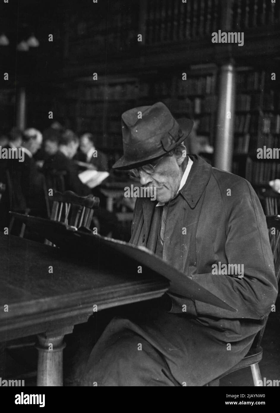 Westminster Libraries. - In einer großen Londoner Bibliothek. Typisch für viele alte Herren, die regelmäßig die Referenzbibliothek besuchen, ist dieser Leser, tief in seinem Exemplar einer illustrierten Wochenzeitung. 14. September 1951. (Foto von Pictorial Press). Stockfoto