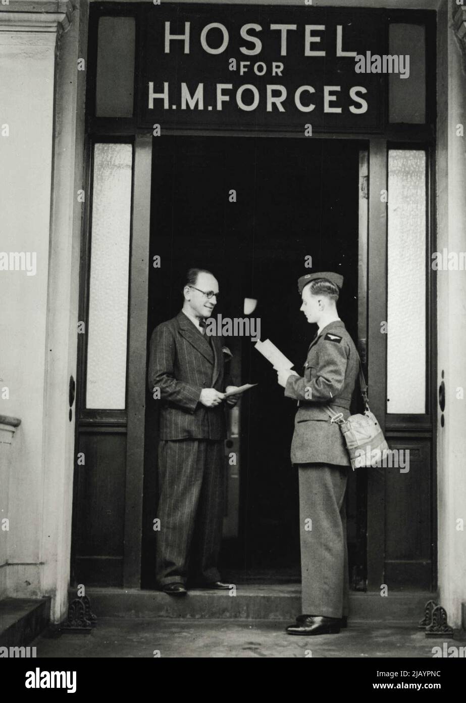 Hotelunterkunft für 2/- Pro Nacht - auf dem aristokratischen Eaton Square -- ein R.A.F.-Mann fragt nach den "Bedingungen" im 2/- Eaton Square "Hotel" - eine typische Szene an der Eingangstür des Hotels. Wenn Sie Mitglied eines der drei Dienste sind, können Sie jetzt eine Hotelunterkunft auf dem aristokratischen Eaton-Platz für nur 2/- pro Nacht haben. Die katholische Herberge für Männer - wo das 2/- Bett und Frühstück erhältlich ist - wurde jetzt von Kardinal Hinsley auf dem Eaton-Platz eröffnet, und obwohl sie von einer römisch-katholischen Organisation betrieben wird, sind uniformierte Gäste jeder Konfession alle Herzlich Willkommen. Stockfoto