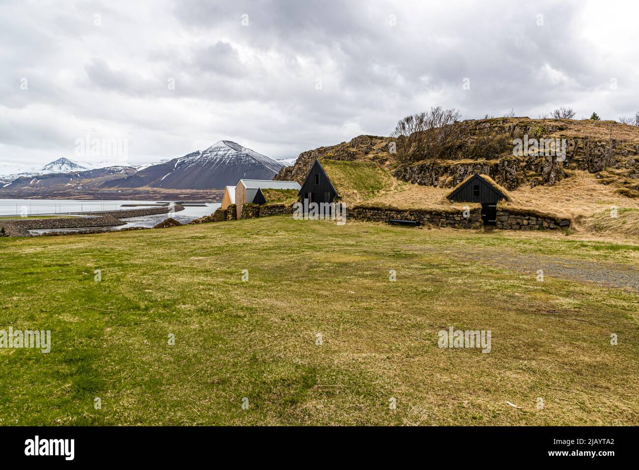 Erdhäuser vor Pyramidenbergen in Borgarnes, Island Stockfoto