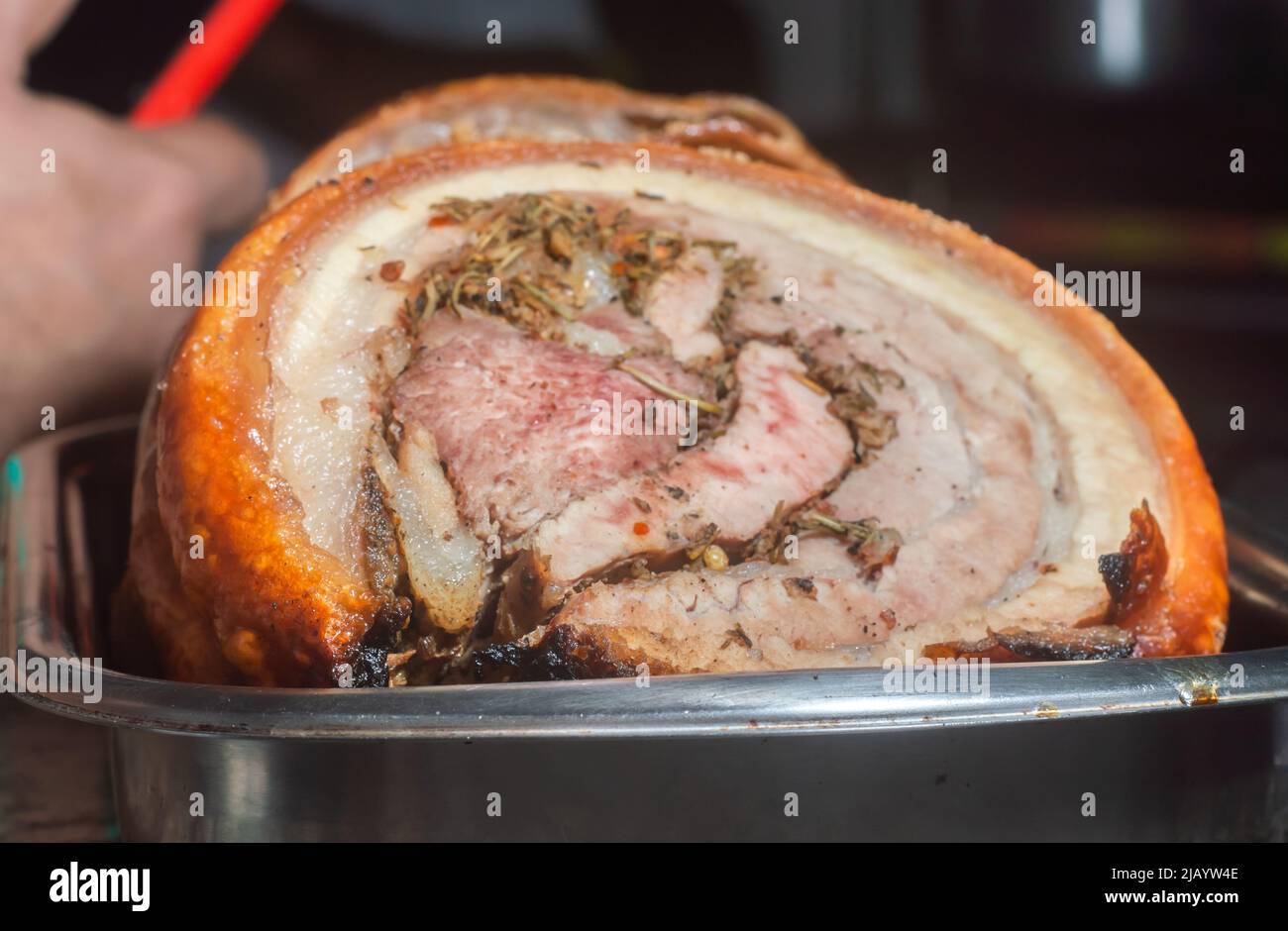 Traditionelle Röstung von italienischer Porchetta, in Scheiben geschnitten und auf einem Metallteller platziert. Stockfoto