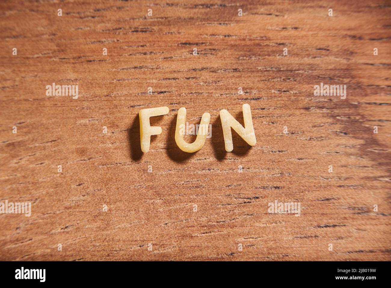 Word Fun mit Alphabet Suppe Pasta Buchstaben auf einem hölzernen Hintergrund gebildet. Stockfoto