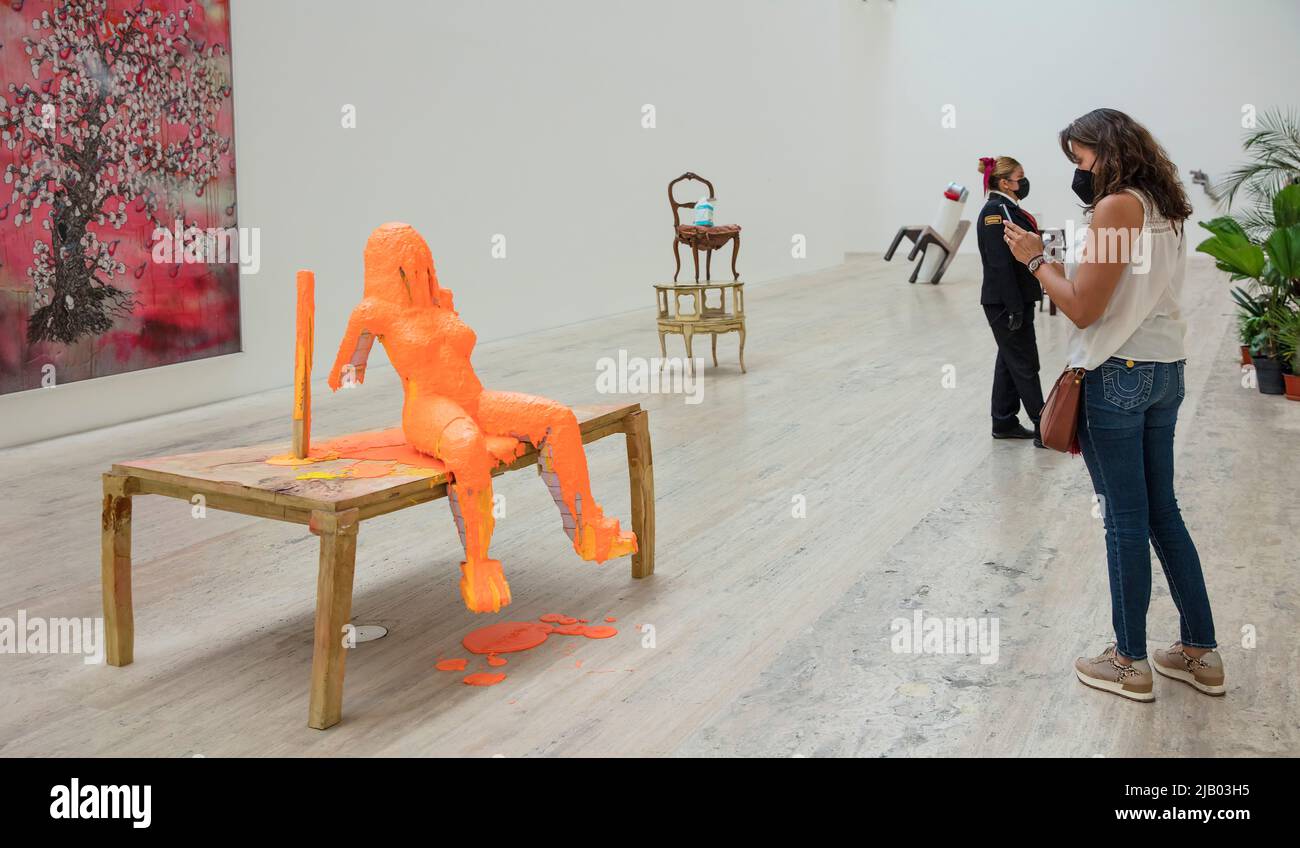 Frau mit Gesichtsbemalung während der Covid-19-Pandemie nimmt im Jumex Museum ein Smartphone-Bild von Kunstwerken des Schweizer Konzeptkünstlers Urs Fischer auf Stockfoto