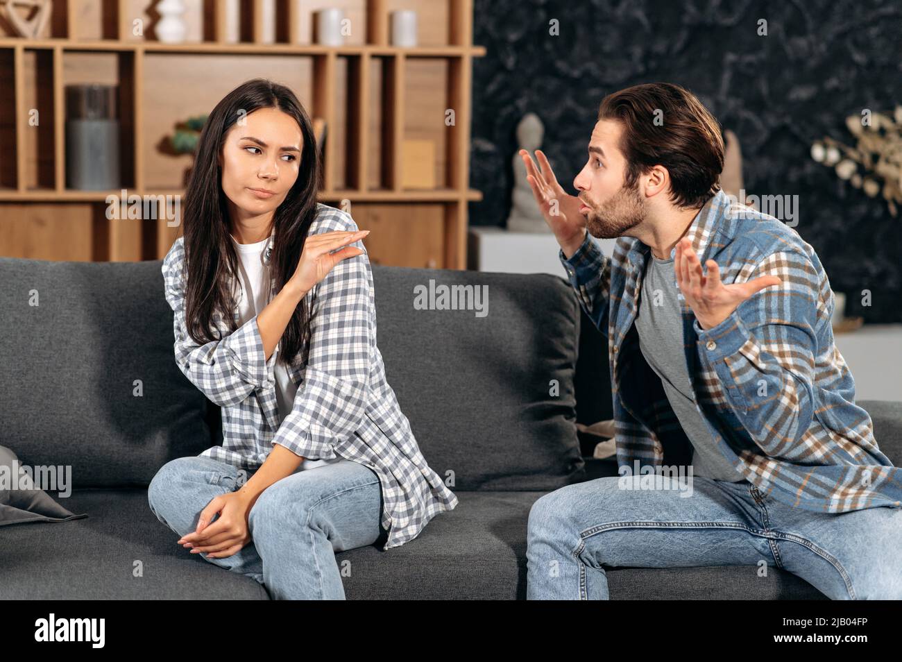 Klärung der Beziehungen zwischen Ehepartnern. Wütender Mann brüllt eine Frau an, fühlt sich wütend, streitig über Meinungsverschiedenheiten, Frau erlebt psychologischen Missbrauch von ihrem Mann, braucht Schutz Stockfoto