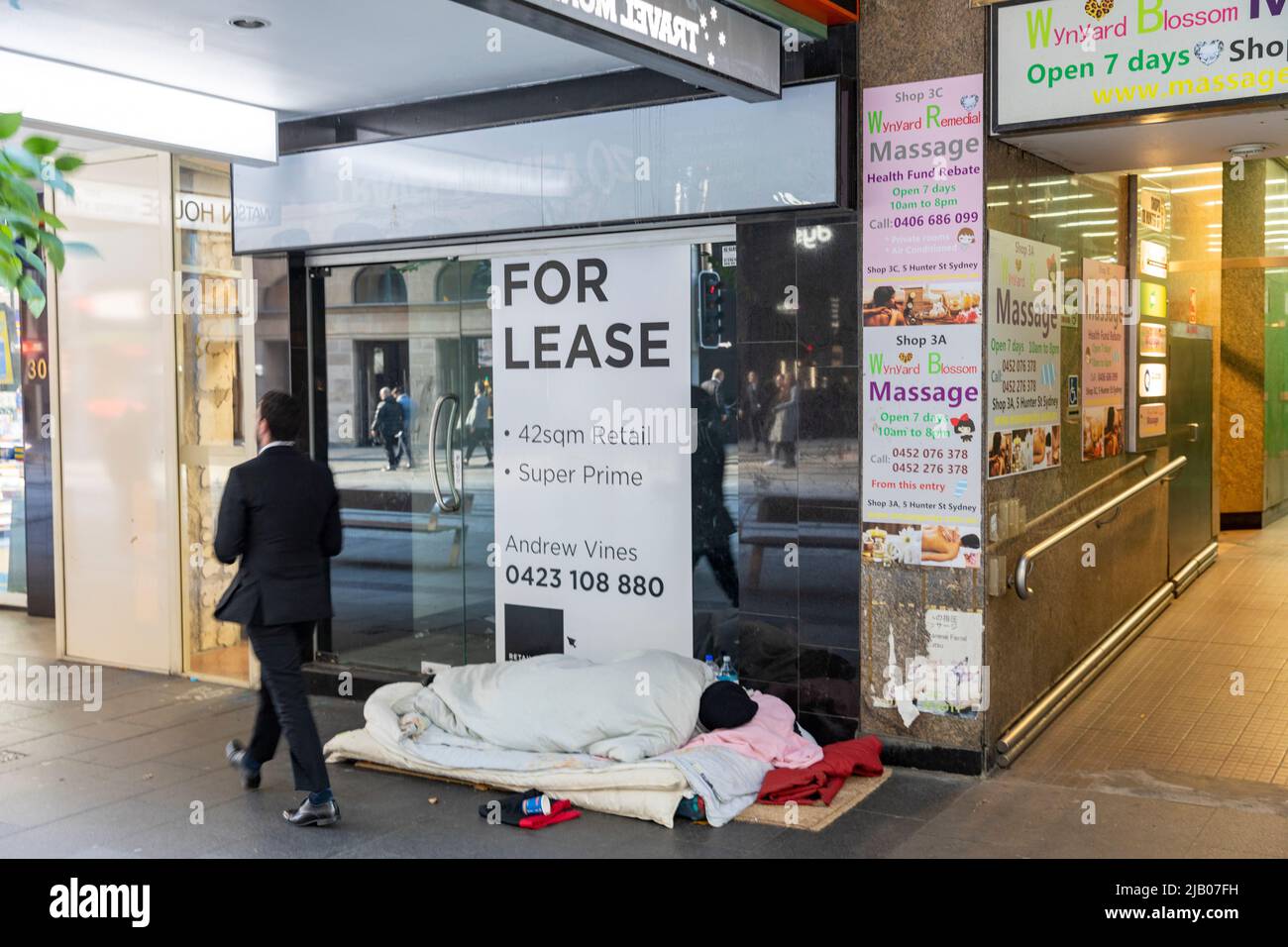 Person, die auf der Straße im Stadtzentrum von Sydney wohnt und schläft, außerhalb des Einkaufszentrums für Mietverträge, obdachlos, Sydney im Winter, NSW, Australien Stockfoto