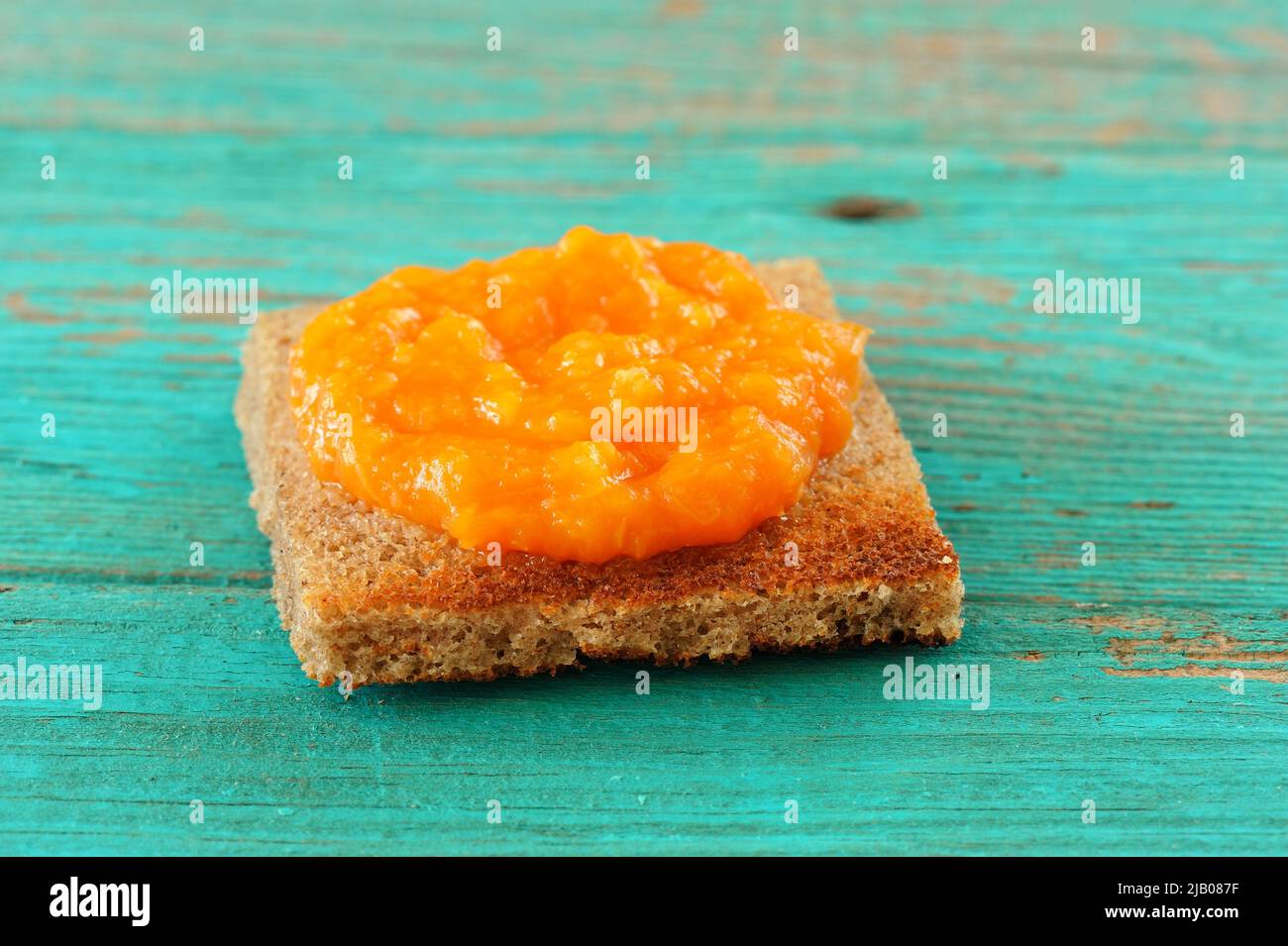 Hausgemachte leckere Kürbismarmelade auf Roggenbrot Toast auf Holztisch horizontal Stockfoto