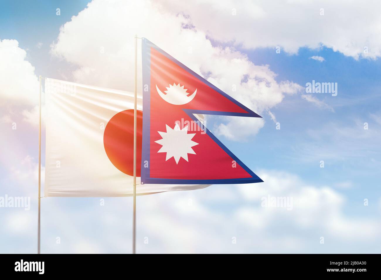 Sonniger blauer Himmel und Flaggen von nepal und japan Stockfoto