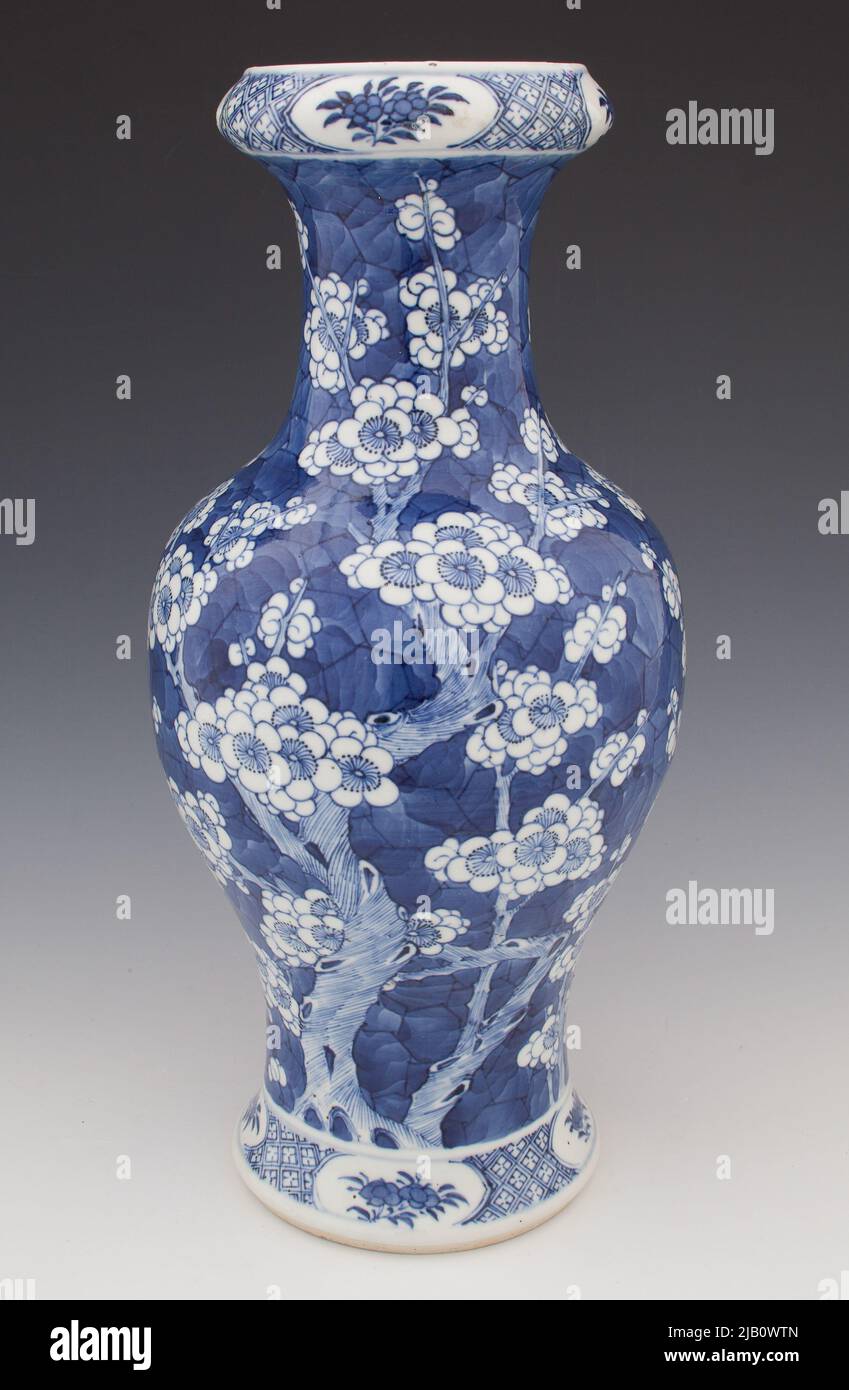 Vase mit Dekoration von blühenden Pflaumenzweigen auf Kobalt-Hintergrund unbekannt Stockfoto