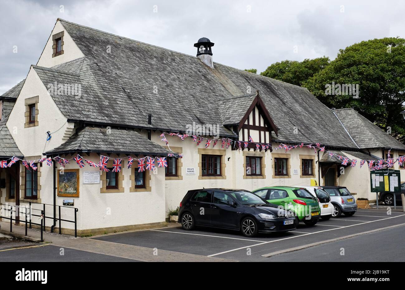 Dorfhalle im hübschen Dorf Silverdale, Lancashire mit Union Jack-Fahnen, die an ihr für das Platin-Jubiläum von Königin Elizabeth II hängen Stockfoto