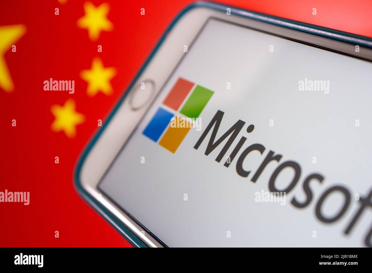 Kumamoto, JAPAN - Mär 10 2021 : Microsoft-Logo auf dem iPhone mit chinesischer Flagge im Hintergrund. Cyberangriff, IT-Technologierisiko und Konfliktkonzept Stockfoto