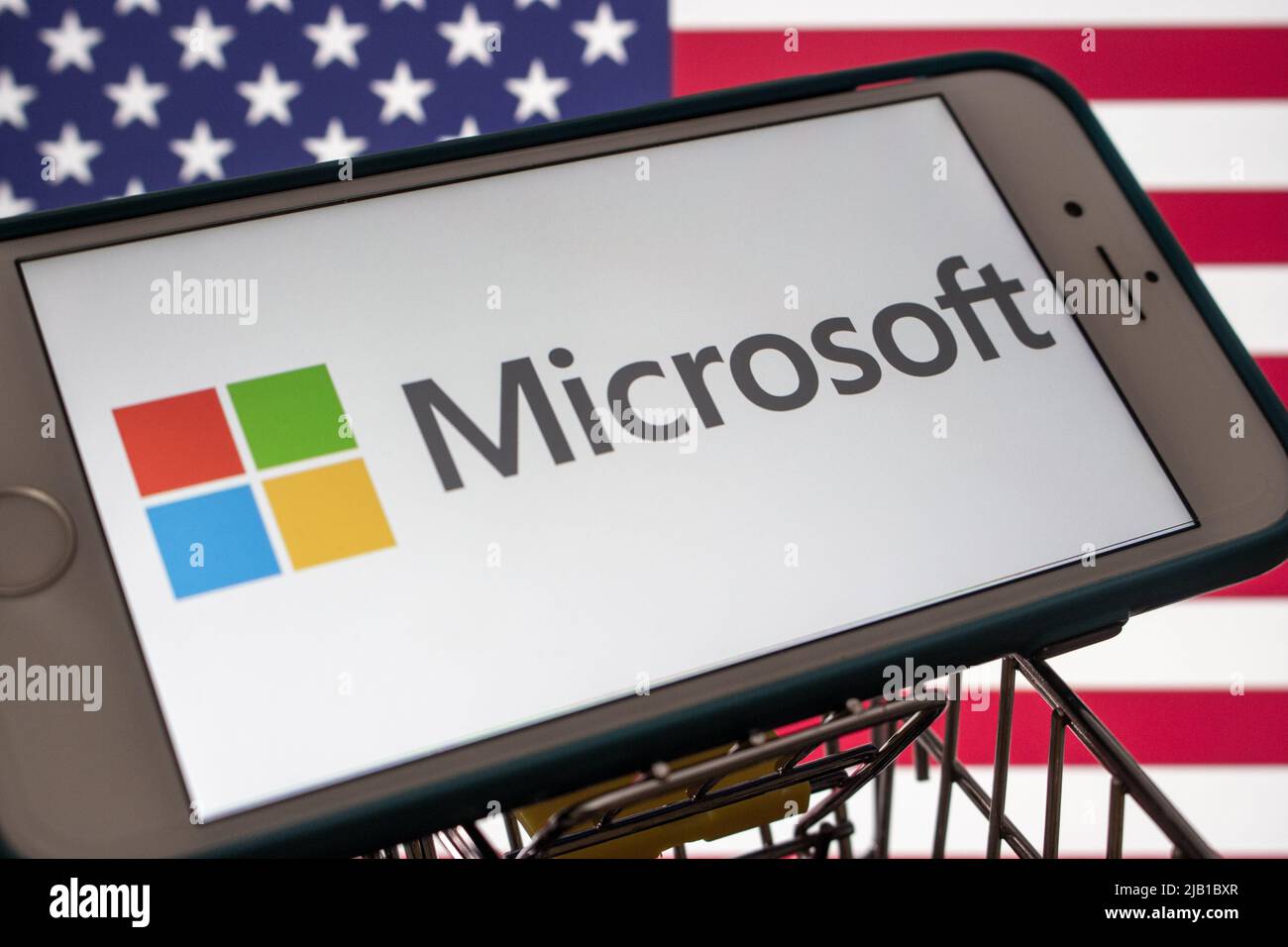 Kumamoto, JAPAN - Mär 10 2021 : ein Microsoft-Logo des US-amerikanischen Technologieunternehmens auf einem iPhone mit US-Flagge. Stockfoto