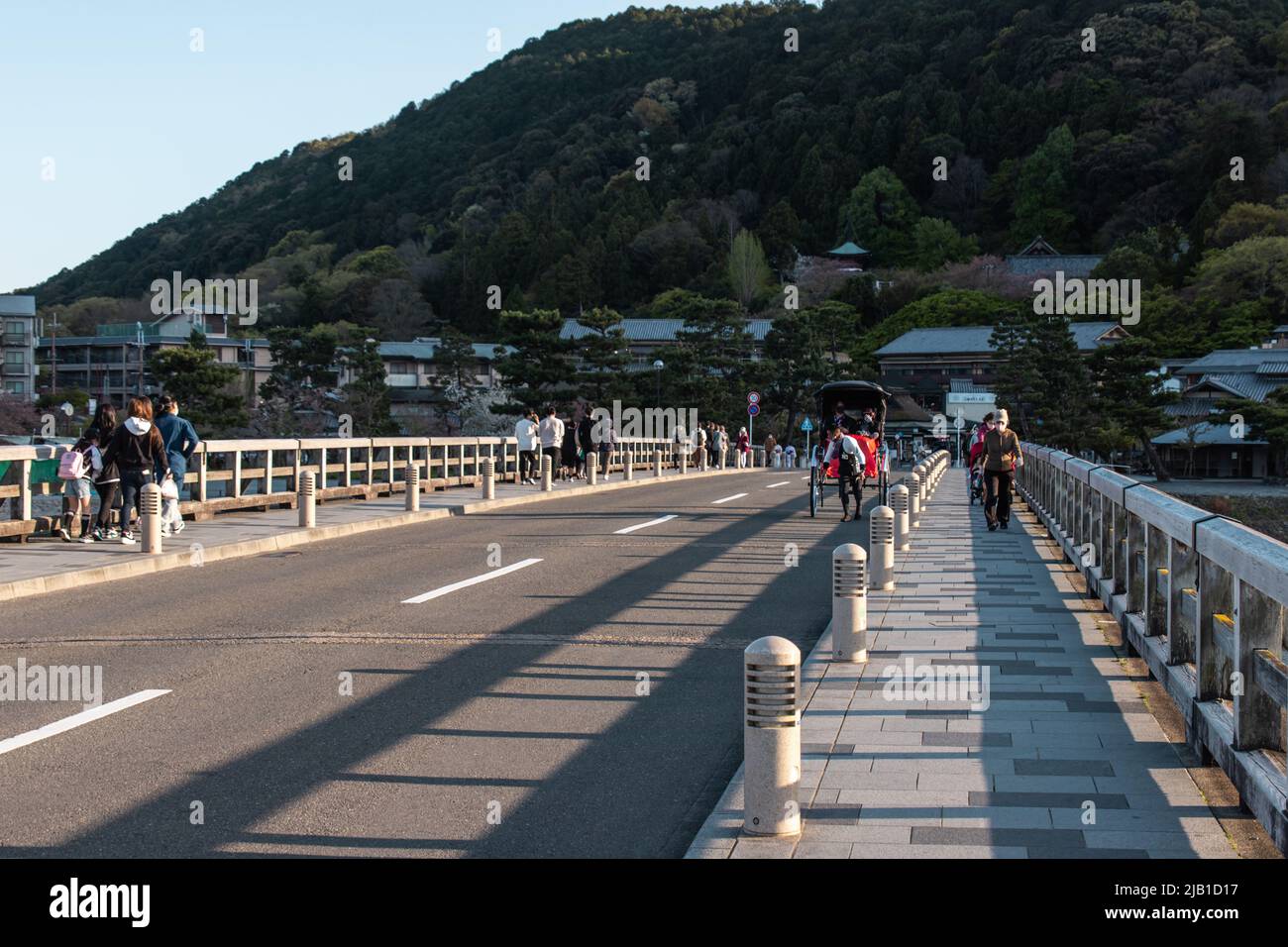 Kyoto, JAPAN - 5 Apr 2021 : die Togetsukyo-Brücke, eine Brücke über den Katsura-Fluss, die in der Dämmerung gemütlich durch das Gebiet von Saga Arashiyama fließt Stockfoto