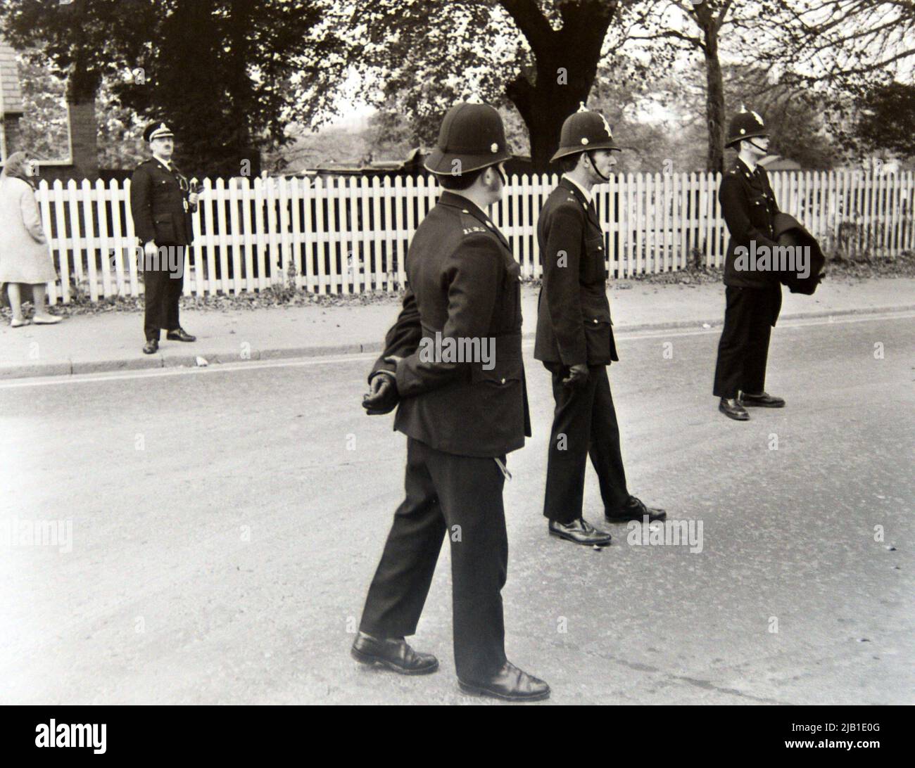 Polizeibeamte, die eine Anti-Rassismus-Demonstration überwachten, marschierten 1972 durch Leicester, England, Großbritannien und die britischen Inseln. Ein leitender Beamter steht auf dem Bürgersteig, um die Aufsicht zu übernehmen. Stockfoto