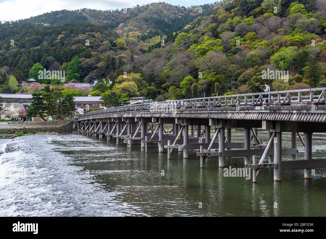Kyoto, JAPAN - 5 Apr 2021 : die Togetsukyo-Brücke, eine Brücke über den Katsura-Fluss, die bei bewölktem Wetter gemütlich durch das Gebiet von Saga Arashiyama fließt. Stockfoto