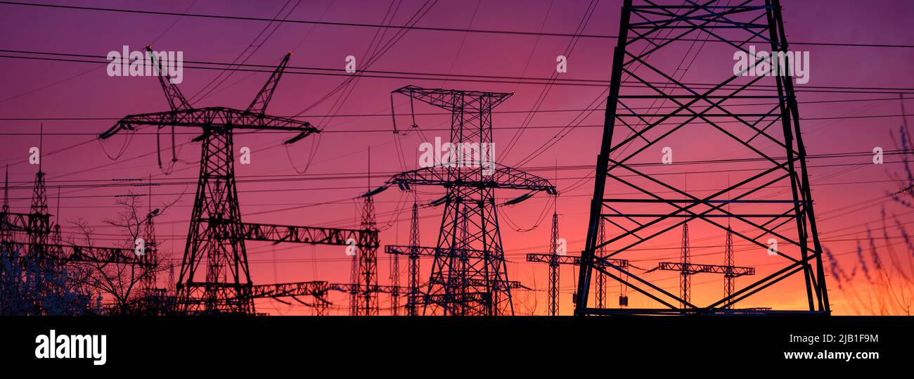Blick auf den Hochspannungsmast bei Sonnenuntergang. Panorama Hochspannungsturm mit Stromleitungen. Stockfoto