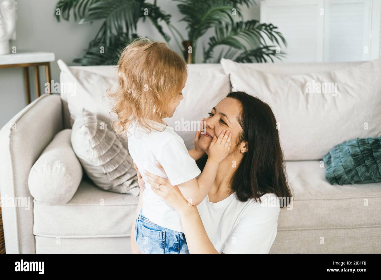 Eine Mutter umarmt ihre vierjährige Tochter sanft. Stockfoto